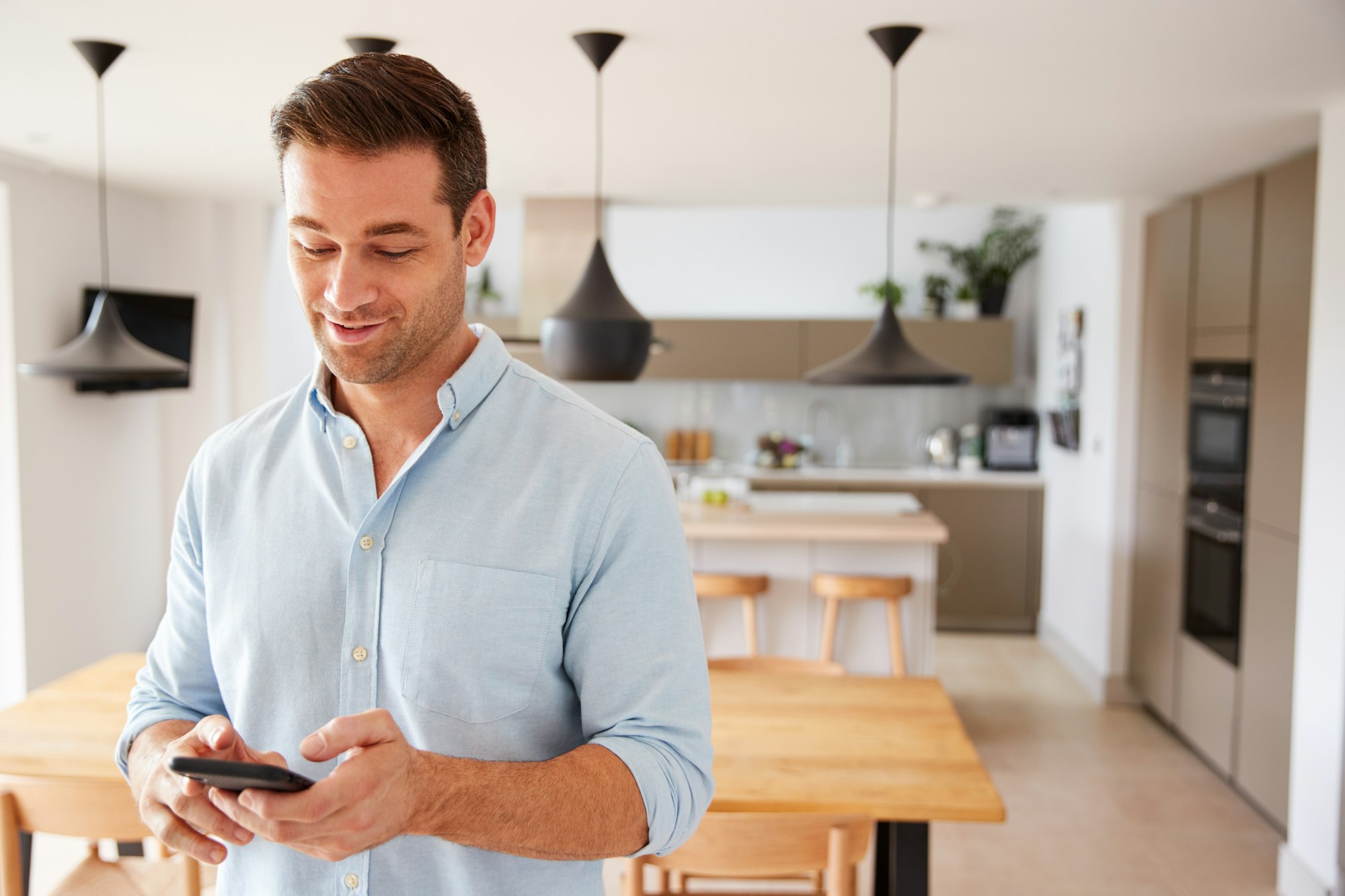 man-using-app-on-smart-phone-to-control-central-heating-temperature-in-house